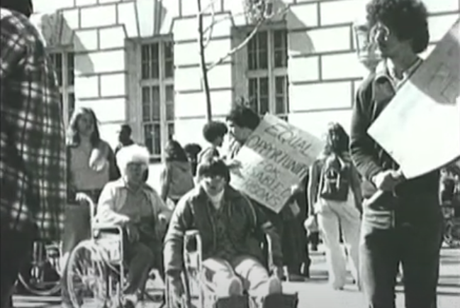 Historic photo from the 504 Sit Ins, disabled protesters hold up signs